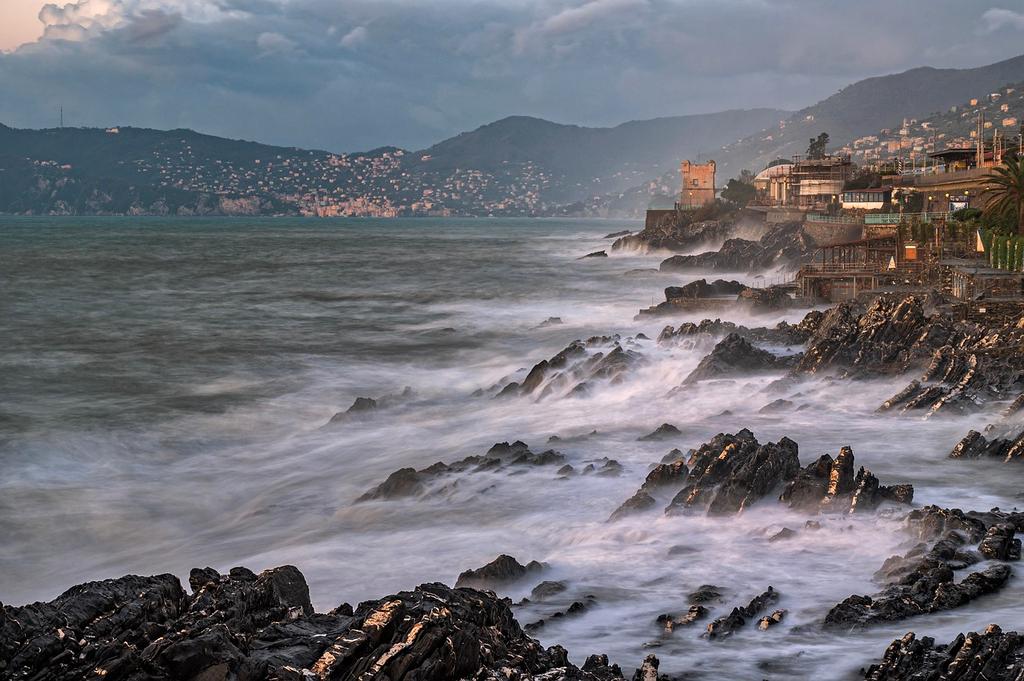 Sunlit coastal cliffs with blue ocean waves crashing below